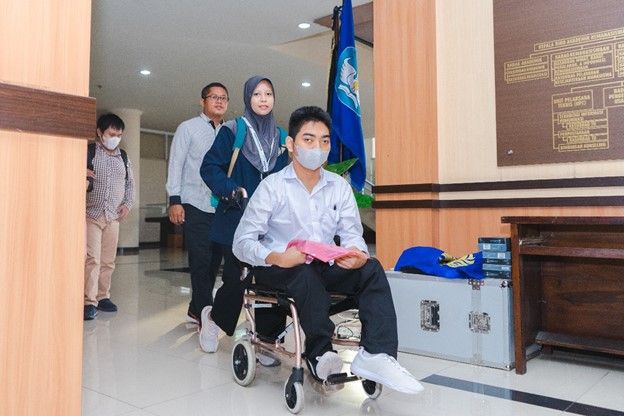 Accompanied by lecturers and students, disabled participants, Akbar Pratama seemed enthusiastic about entering the UTBK test room at the Training Center, UNESA Rectorate.