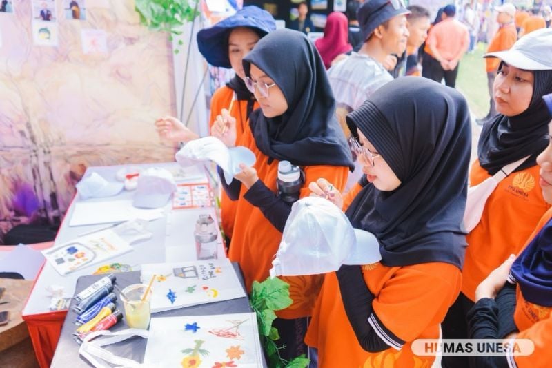 The excitement of visitors competing with creativity at one of the PPG UNESA student exhibition booths.