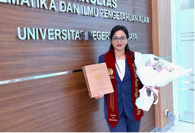 Desak Made Anggraeni, doctoral graduate of Science Education, FMIPA Unesa, shows his dissertation as a result of his research and struggle so far.