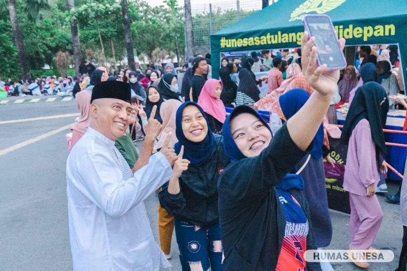 UNESA Chancellor Cak Hasan took a selfie with students during the agenda for takjil and breaking fast together