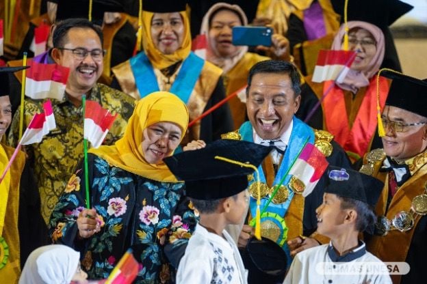 A RARE MOMENT: The leadership, partners and Khofifah Indar Parawansa witnessed the expression of one of the orphans when Chancellor Cak Hasan wore a toga.