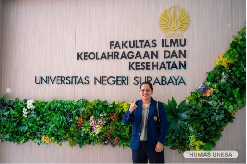 Leani Ratri Oktila poses with her UNESA alma mater in front of the FIKK building.